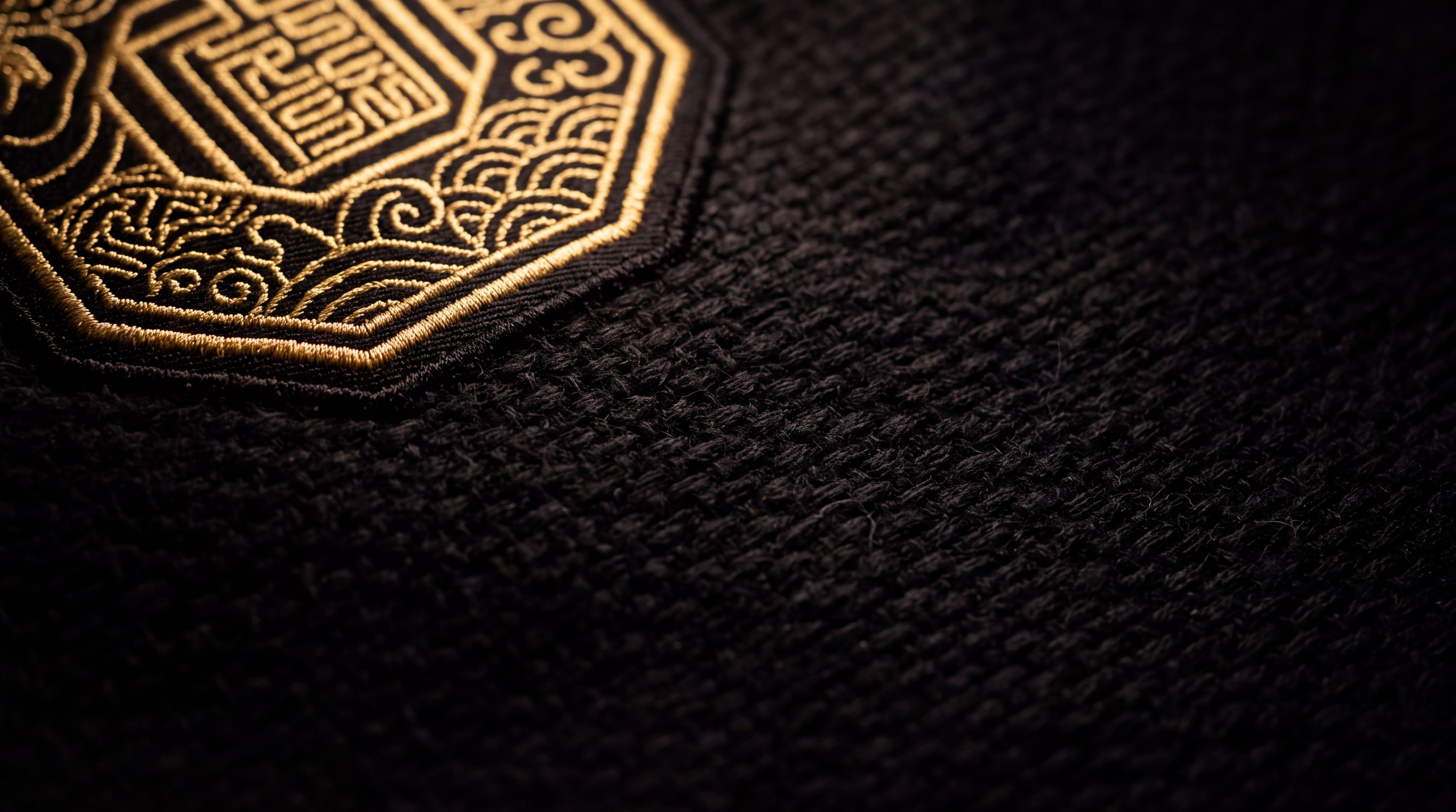 Tissu noir avec un emblème brodé de fil d'or
